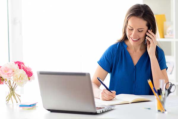 Woman on phone using laptop