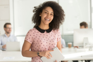 Happy african businesswoman holding digital tablet looking at camera